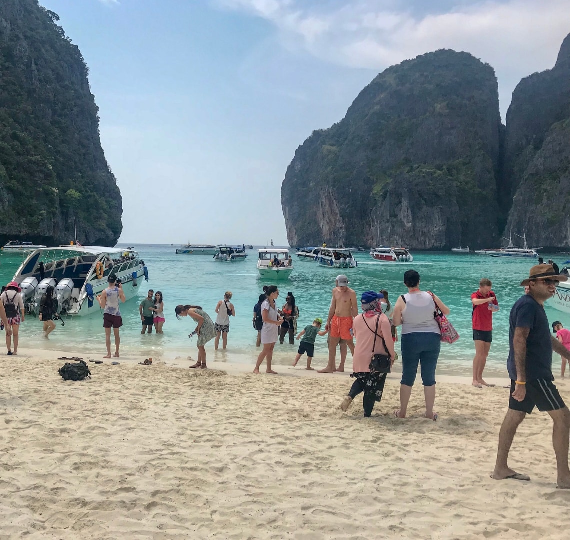 Volunteer tourism - a photo of the crowded beach on Koh Phi Phi with lots of boats coming and going