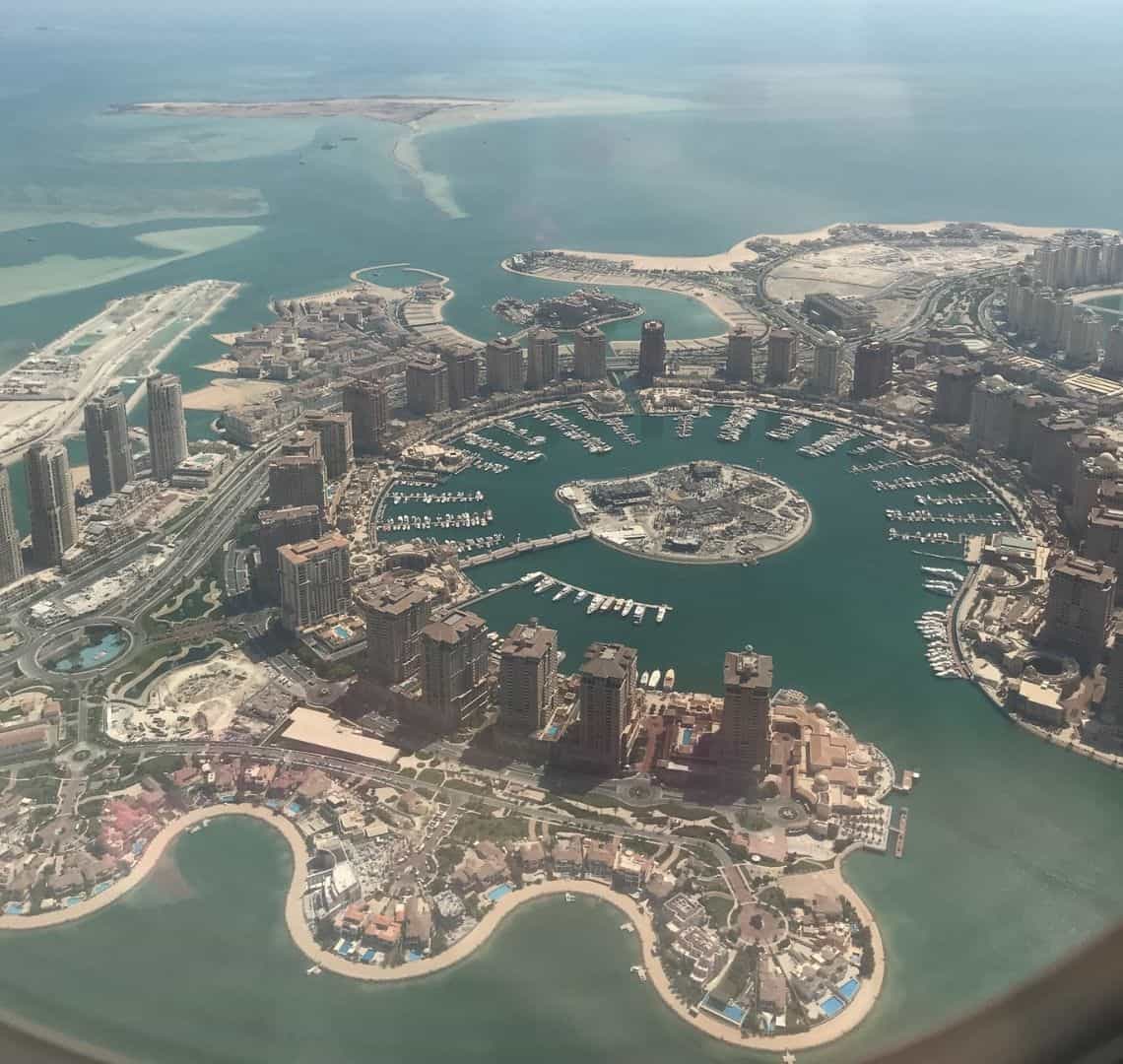 How to Repatriate Well - Dona from a plane. The circular layout of the pearl with its sand bars, high rise condominiums and aqua sea is visible from the window