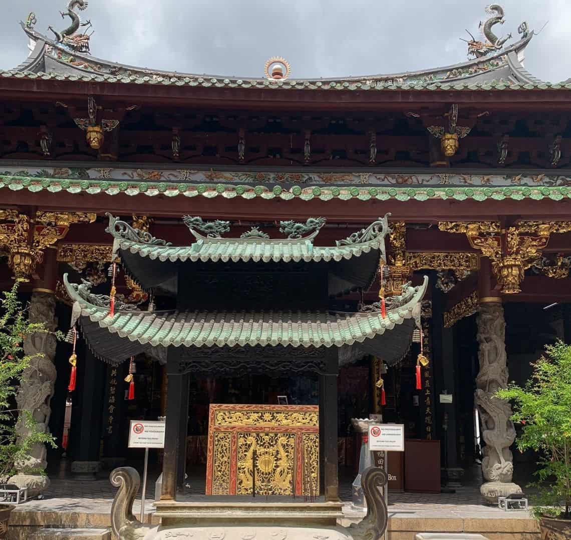 Thing Hock Keng Temple from the front with oxidised Chinese roof, ornate carved pillars and gold left on the beams 