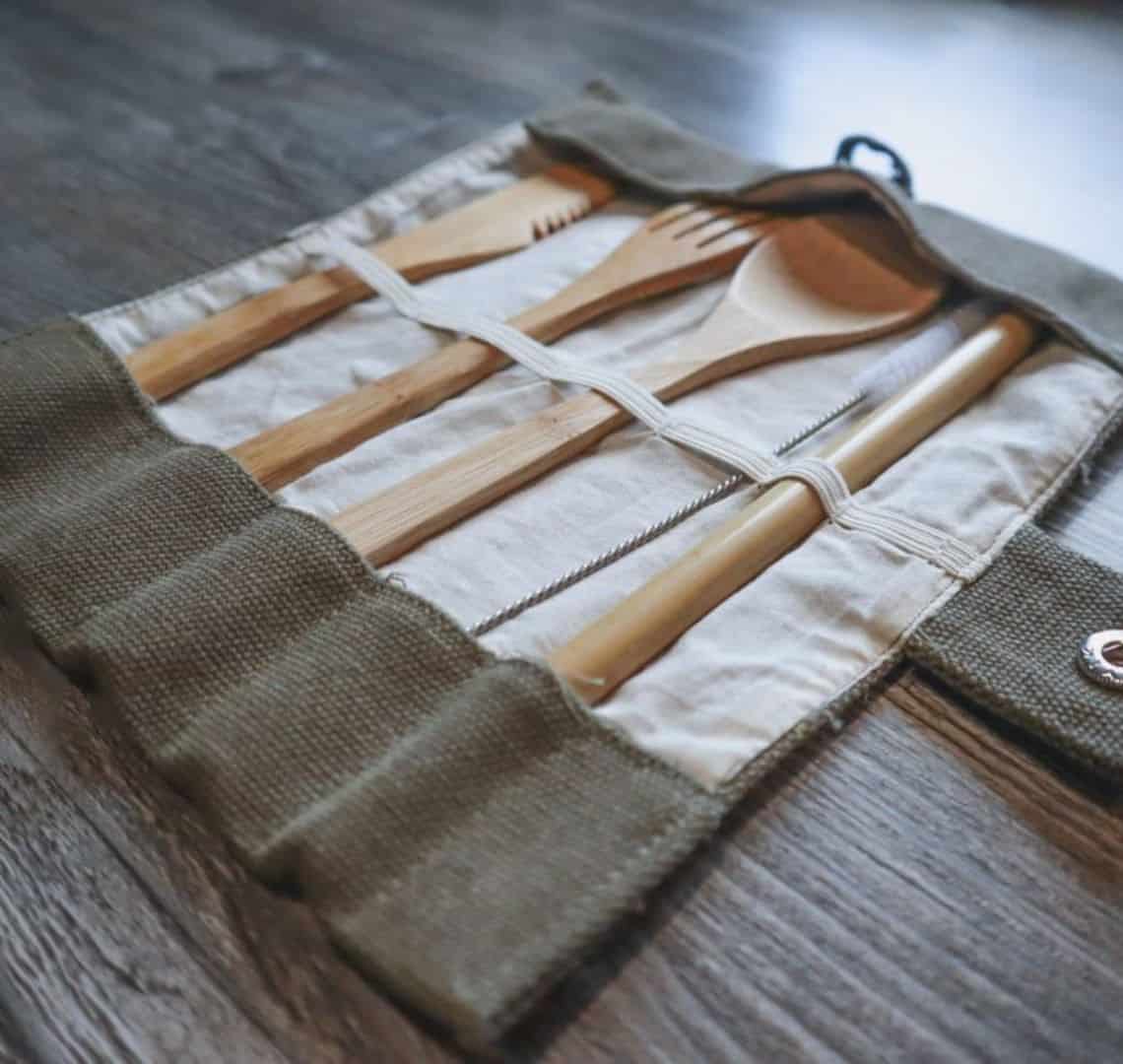 Image of bamboo cutlery (knife, then fork, then spoon, then straw) in a roll-up bag.