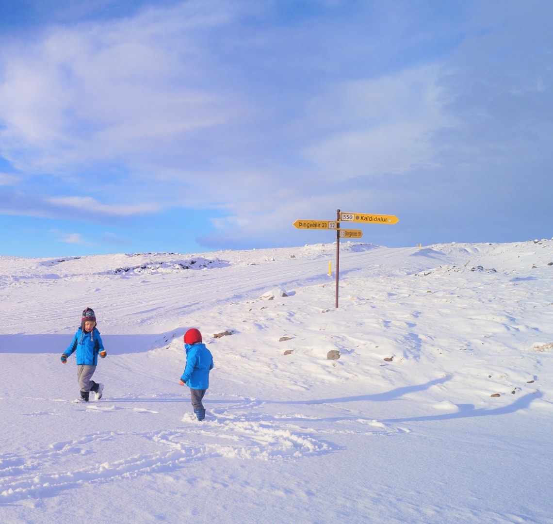 Best family holiday destinations m- Travelynn Family's 2 boys playing in the snow during a stop on their drive in Iceland