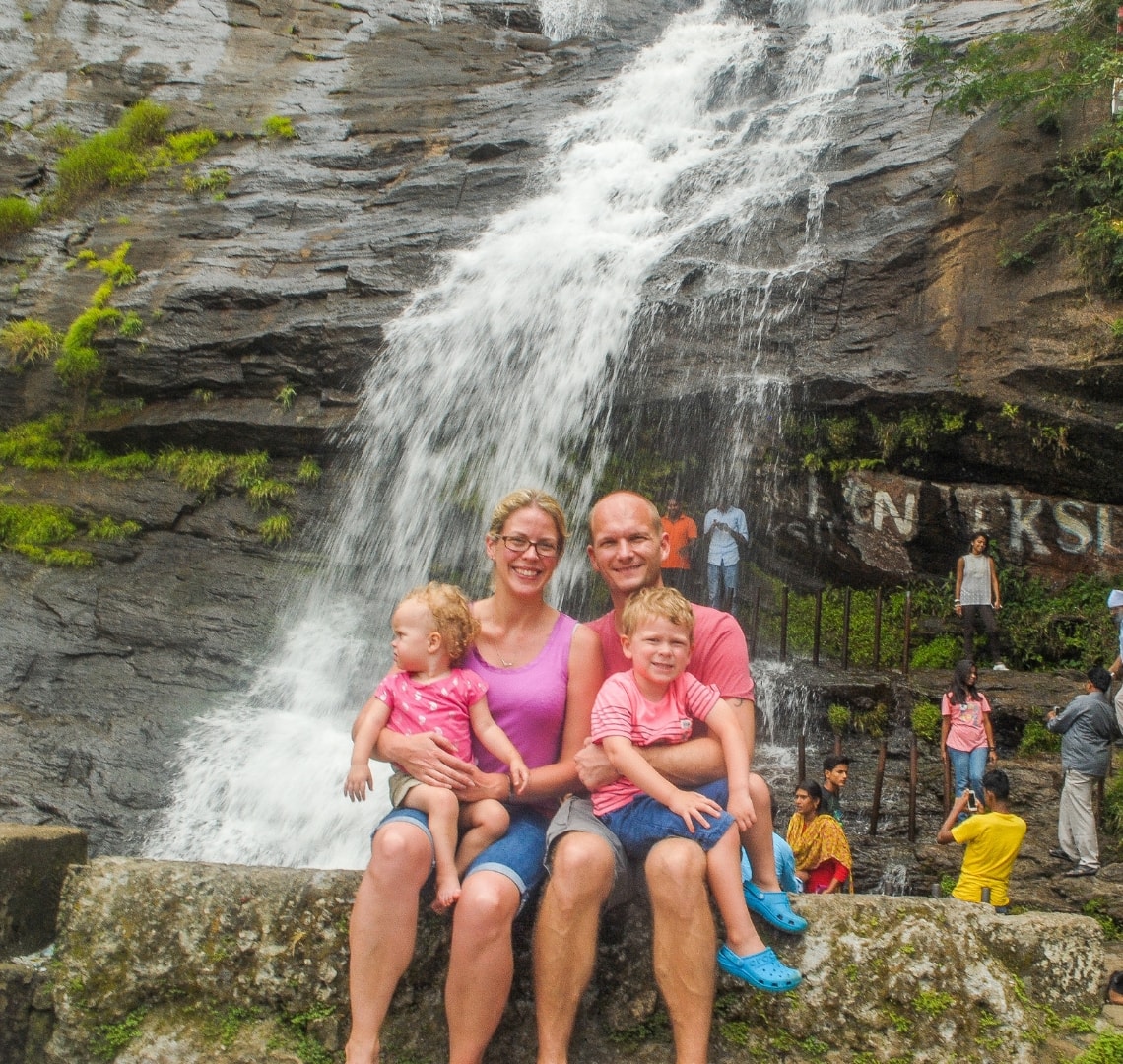 How to have an epic family holiday - Wanderlust family in front of a waterfall in Kerala