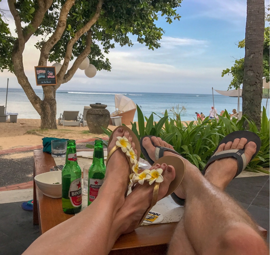 Normal Expat Christmas - View of the ocean in Bali past Mr Wanderlust and I's feet and a couple of beers